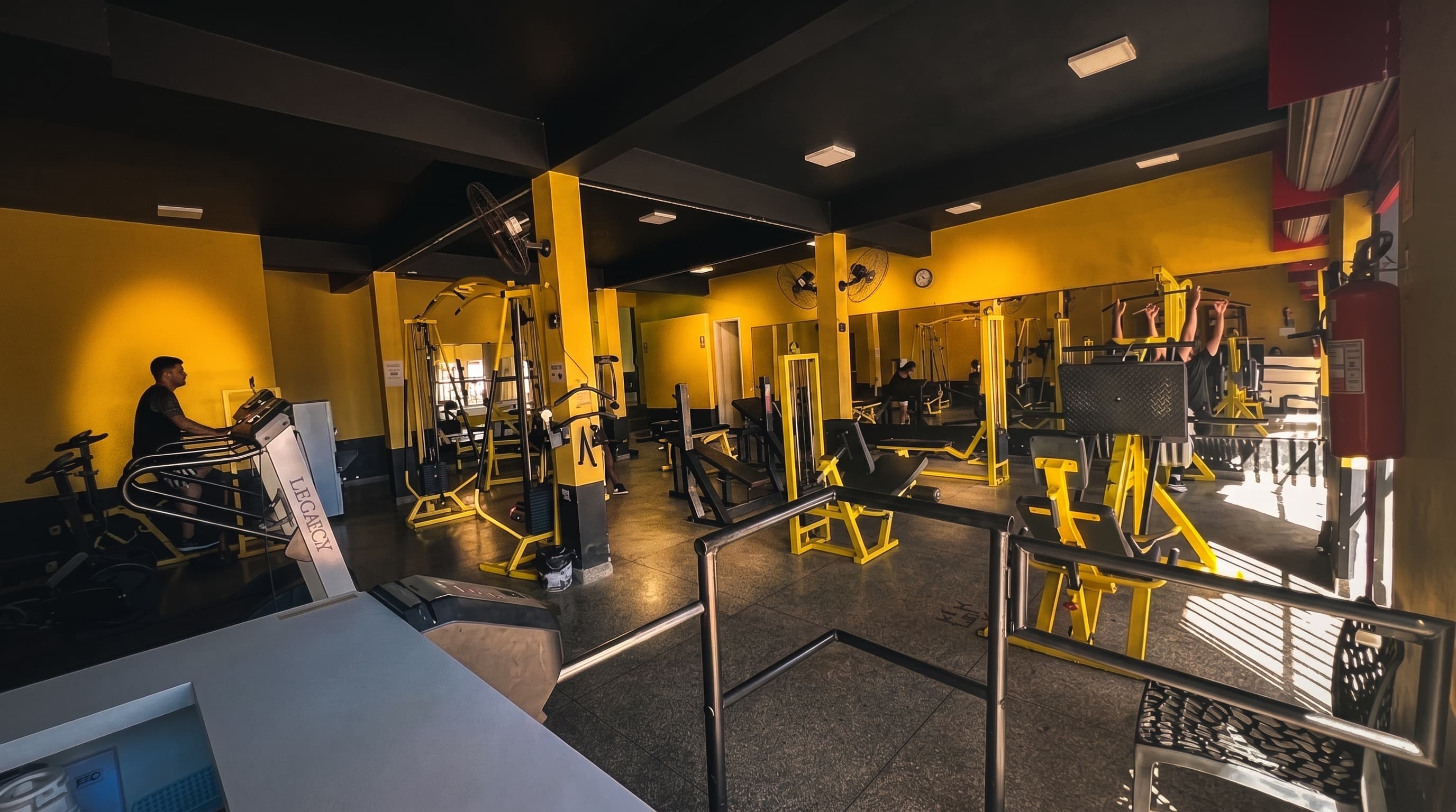 Visão ampla do salão de treino da Academia Versátil